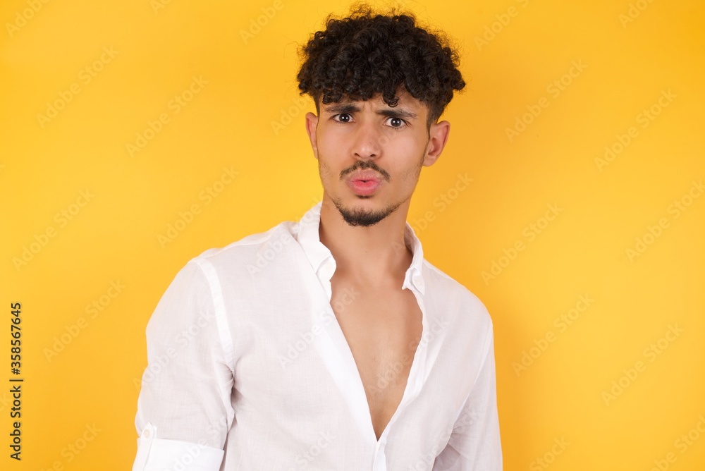 Brunette man in casual clothes expressing disgust, unwillingness, dislike, disregard having tensive look frowning face. Cauasian man with pleasant appearance looking indignant digusting something Brunette man in casual clothes expressing disgust, unwillingness, dislike, disregard having tensive look frowning face. Cauasian man with pleasant appearance looking indignant digusting something