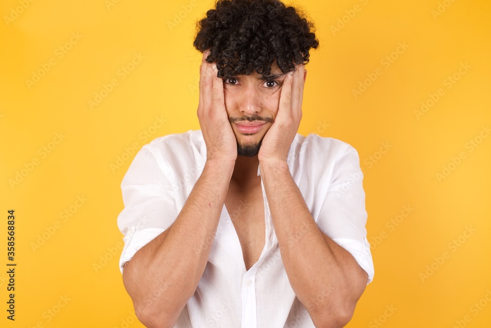 Portrait of beautiful young woman holding head in hands with unhappy expression watching sad movie about animals and trying not to cry. Portrait of beautiful young woman holding head in hands with unhappy expression watching sad movie about animals and trying not to cry.