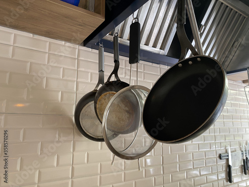 cookware sets hanging on the raw concrete polishing wall for every use in  kitchen
