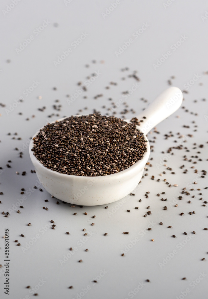 chia seeds in a small white bowl on cooking table chia seeds in a small white bowl on cooking table