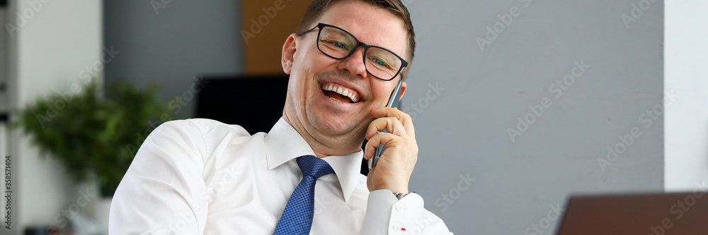 Businessman laughing talking on phone with partner