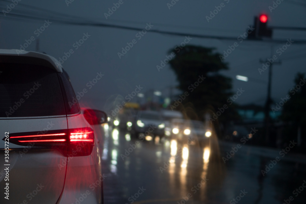 Abstract of cars parked at a traffic signal at an intersection. The road condition is wet with rain. And during the night time. Abstract of cars parked at a traffic signal at an intersection. The road condition is wet with rain. And during the night time.