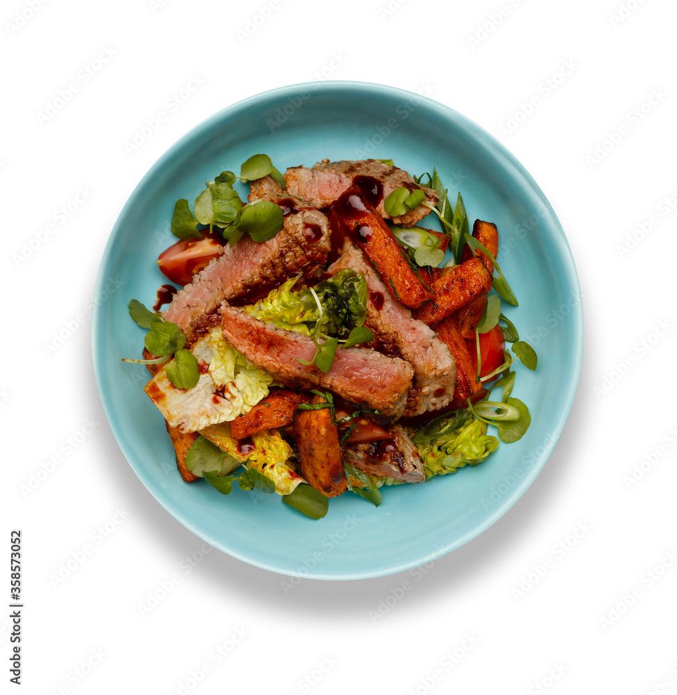 A delicious bowl of BBQ rump steak strips, sweet potatoe chips and vegetables, in a light blue bowl isolated on white background