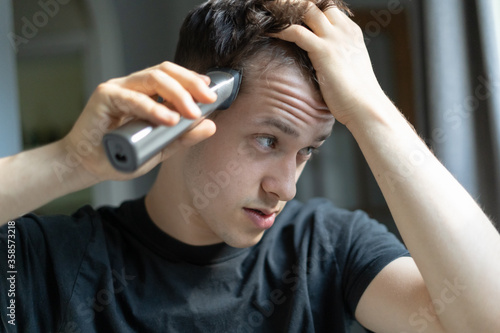 Young man giving himself a haircut