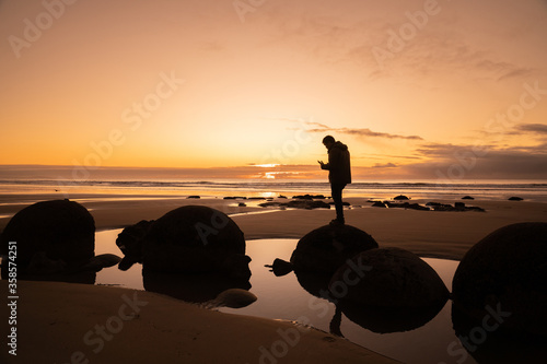 Asian man traveller visit at Moereki Boulder, New Zealand. photo