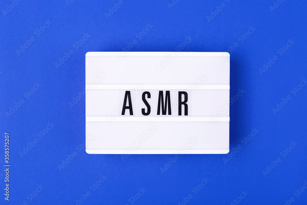 The lamp with letters ASMR on blue background. Sound and visual practice for anxiety, stress and panic relief. Flat-lay. The lamp with letters ASMR on blue background. Sound and visual practice for anxiety, stress and panic relief. Flat-lay.