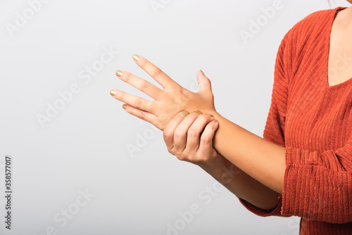 Fotografie Close up hand of Asian woman she holding her acute pain in wrist of hands, studi