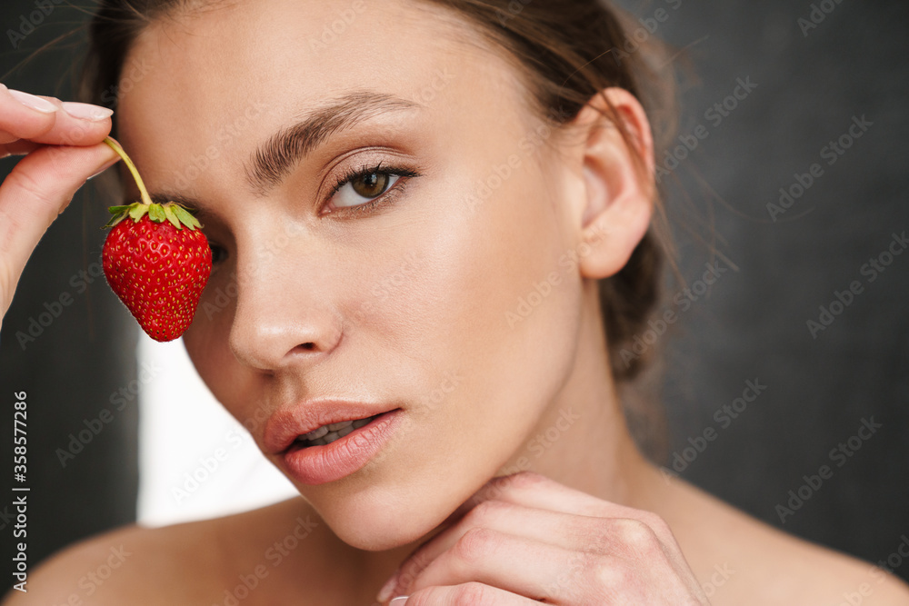 Image of beautiful caucasian young shirtless woman holding strawberry Image of beautiful caucasian young shirtless woman holding strawberry