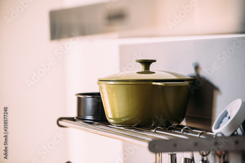 A green pan on a shelf in a kitchen. High quality photo