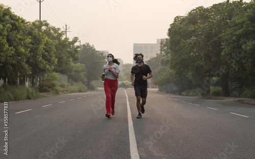 Young Couple wearing masks while running in the morning.