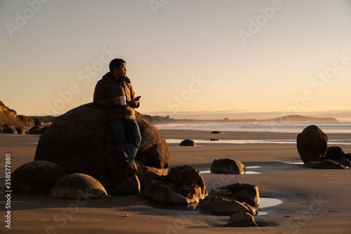 Asian man traveller visit at Moereki Boulder, New Zealand. photo