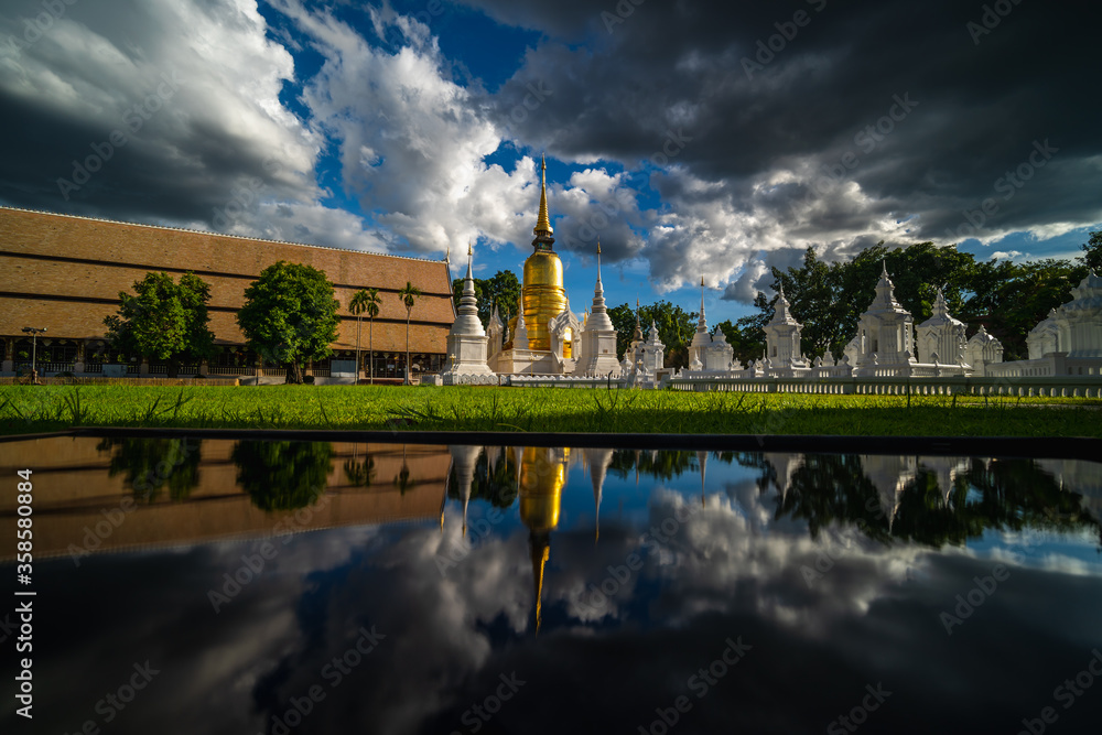 Wat Suan Dok Temple with rain clouds and reflection, is a Buddhist temple and Royal Temple of the Third Class in Chiang Mai  Thailand. Landmark of Chiang mai..