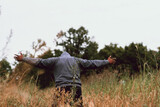 Young man praying in the field with arms held out