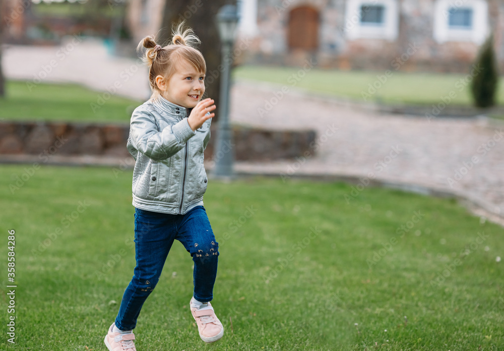 Little beautiful girl having fun outdoors. Cute girl runs on the green grass.
Little beautiful girl having fun outdoors. Cute girl runs on the green grass.