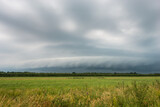 Approaching thunderstorm with arcus (shelf cloud) over plain landscape