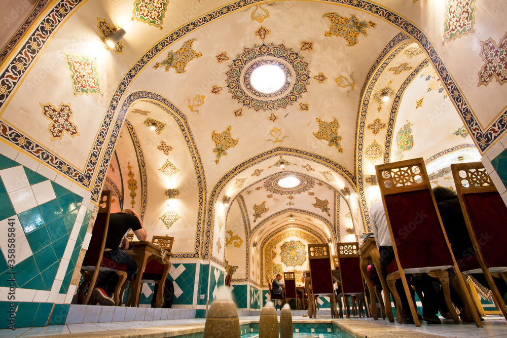 Interior of retro restaurant with traditional painted walls and water fountains, Iran.