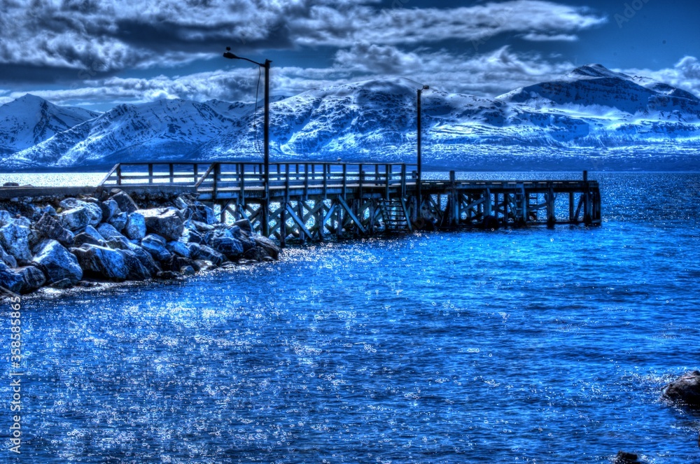 Φωτογραφία majestic pier in dreamy blue fjord with snowy mountain in background