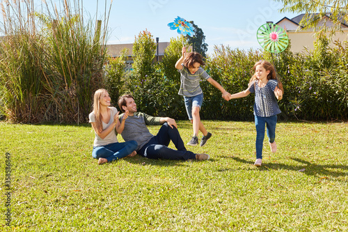 Two kids play hilariously in the garden in summer