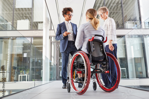Businesswoman in a wheelchair talking to colleagues