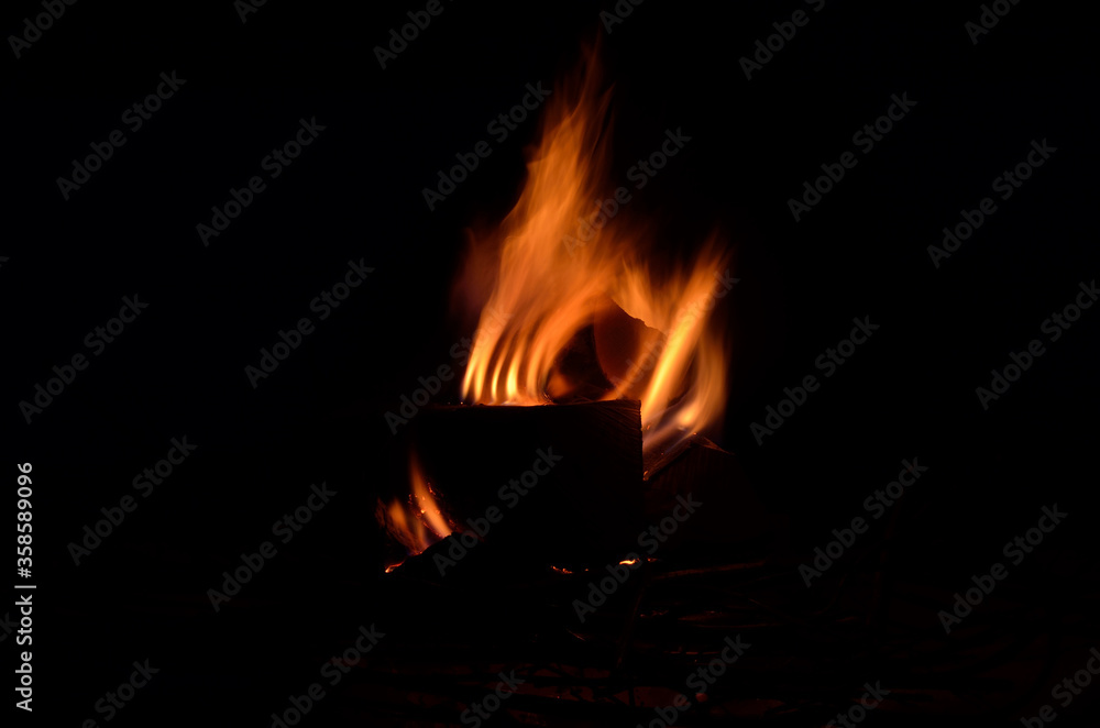 bright burning birch log fire in snowy winter nature at night