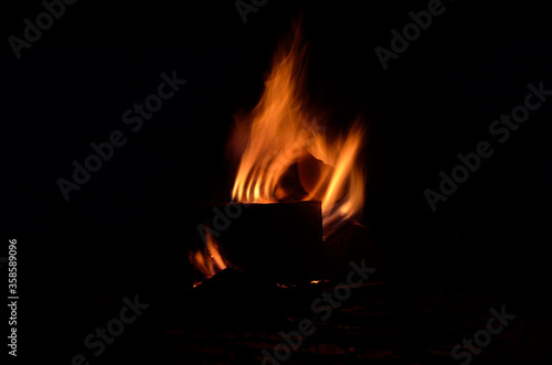 bright burning birch log fire in snowy winter nature at night