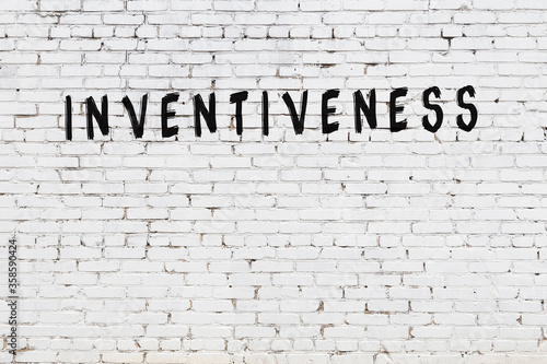 White wall with black paint inscription inventiveness on it