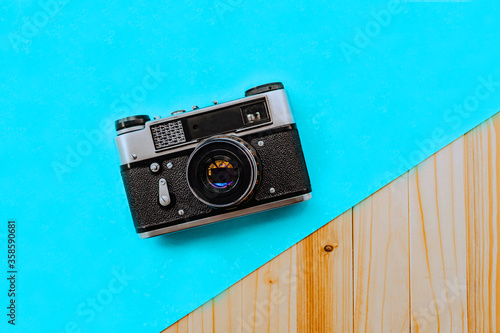 vintage photo camera and lenses with place for design on a blue and wooden background