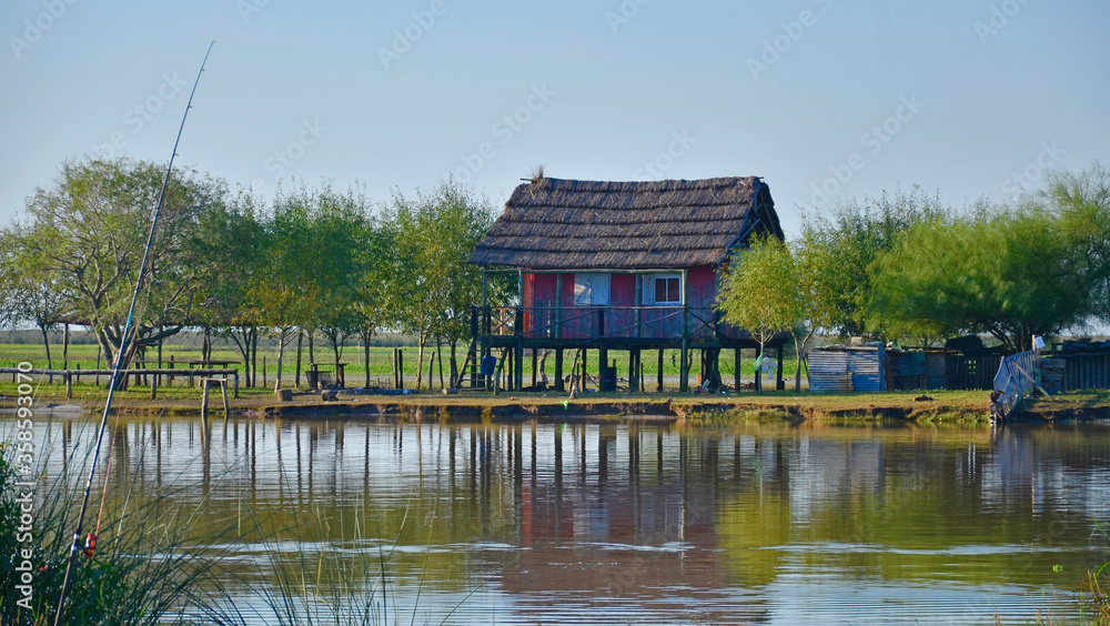 Obraz premium Colorful landscape of rural house on island on river bank.