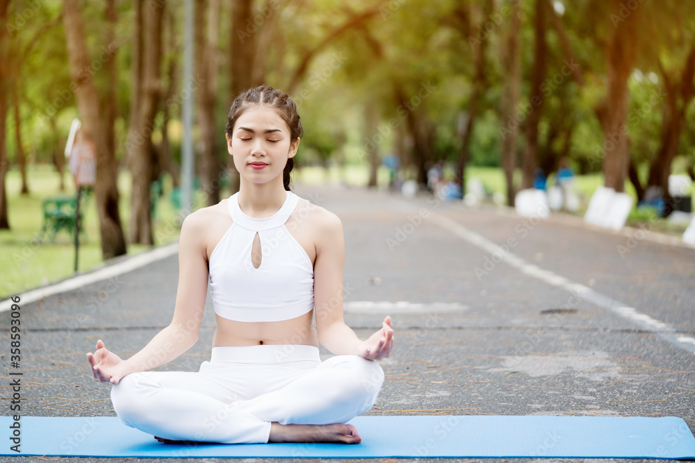 Lifestyle Happy Asian women is Workout or yoga in the great outdoors or the beautiful nature park. Enjoying the physical activity in the summer. Concept Good health