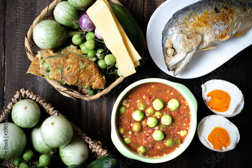 Obraz na płótnie Shrimp Paste Chilli Sauce with Fried Mackerel and vegetable, (nam prik ka pi) on wood table, top view w salonie