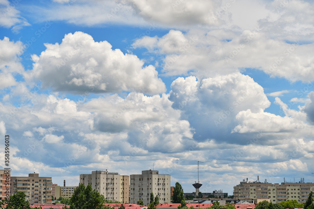 Stratocumulus clouds form a layer and move fast from left to right over city buildings, in a residential neighborhood of Bucharest, Romania, Eastern Europe. Daytime time lapse. Stratocumulus clouds form a layer and move fast from left to right over city buildings, in a residential neighborhood of Bucharest, Romania, Eastern Europe. Daytime time lapse.