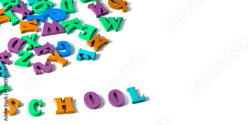 multicolored English alphabet letters and school supplieson a white background