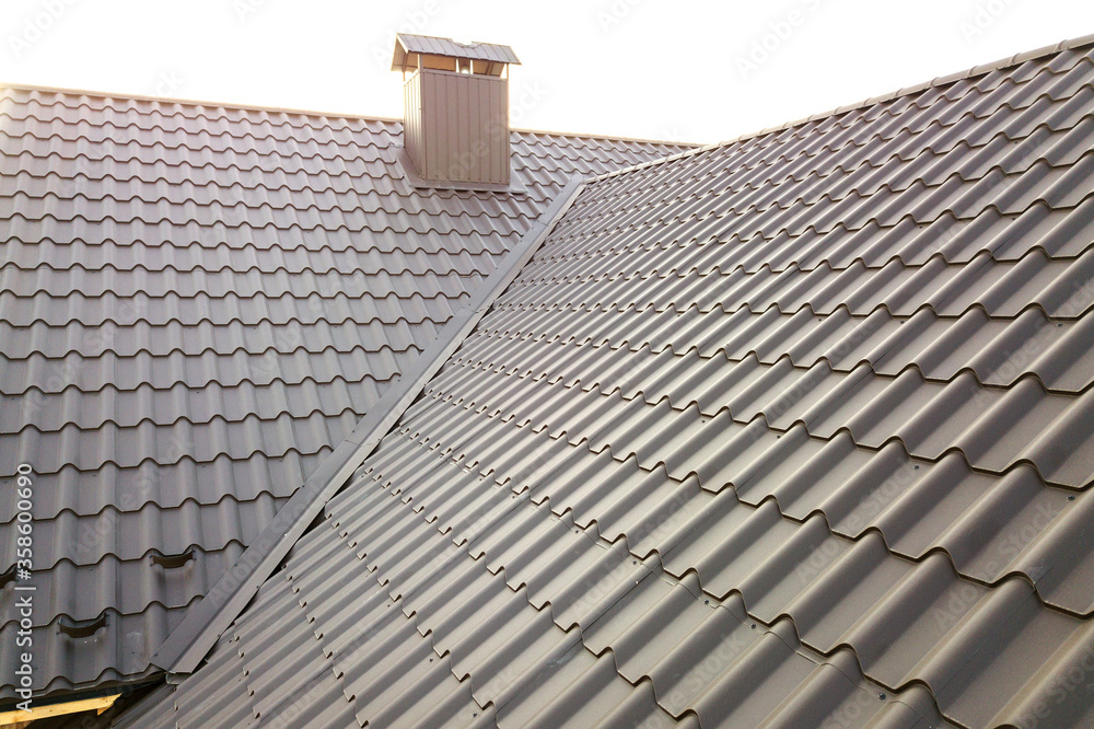 Fototapeta premium Close up of new house roof structure covered with metal tile sheets.