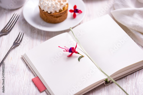 Mockup porcelain plate with cake and opened recice book, notebook, book photo