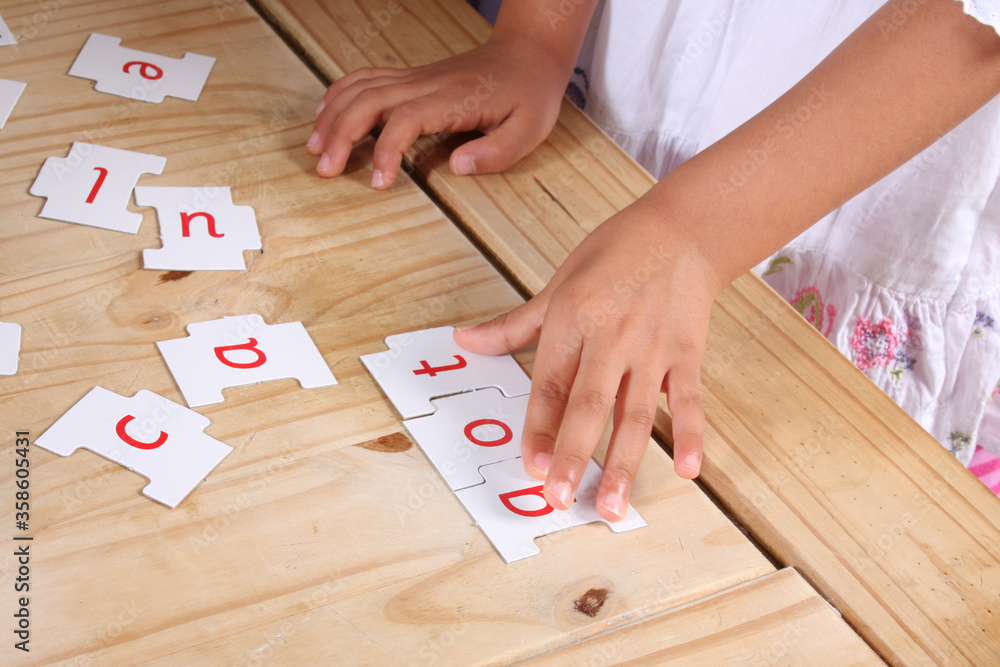 A child's hands moving letters to make a word A child's hands moving letters to make a word