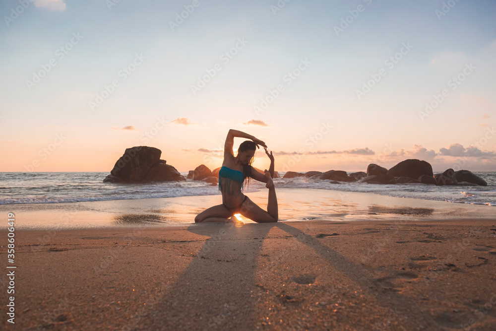 Young attractive latin woman wearing a bikini practicing yoga on the beach at sunset, healthy mental and body lifestyle concept. Yogi pose Young attractive latin woman wearing a bikini practicing yoga on the beach at sunset, healthy mental and body lifestyle concept. Yogi pose