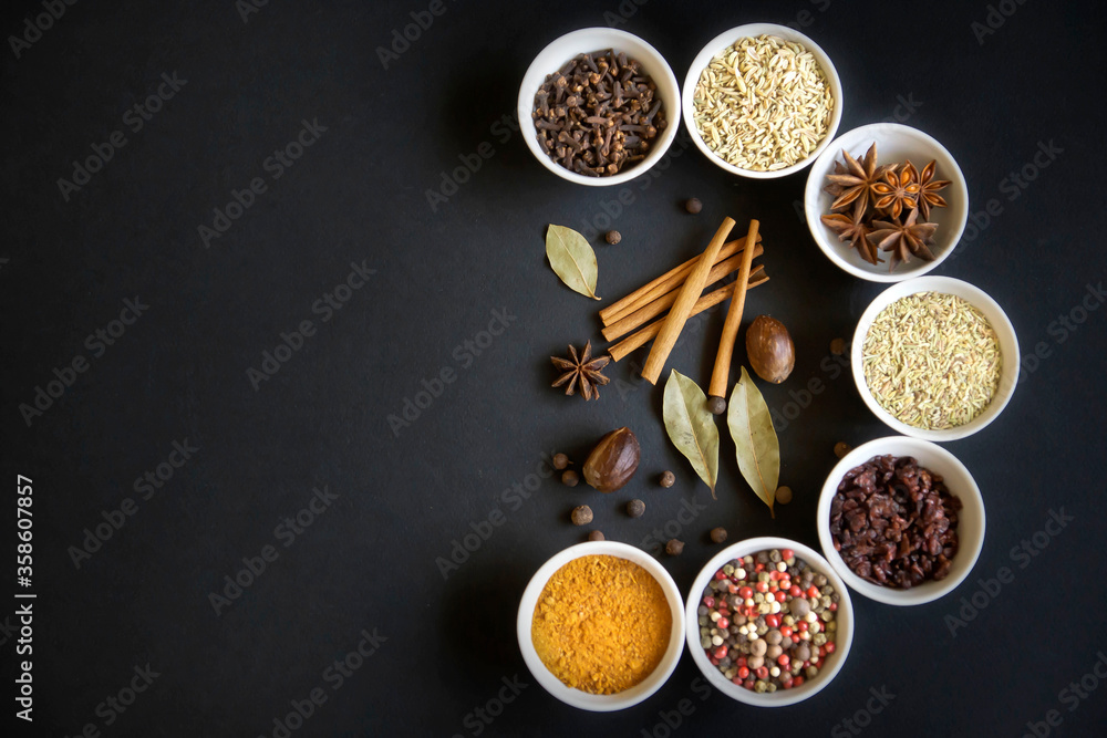 Dry seasonings and spices against a dark background view from the top.