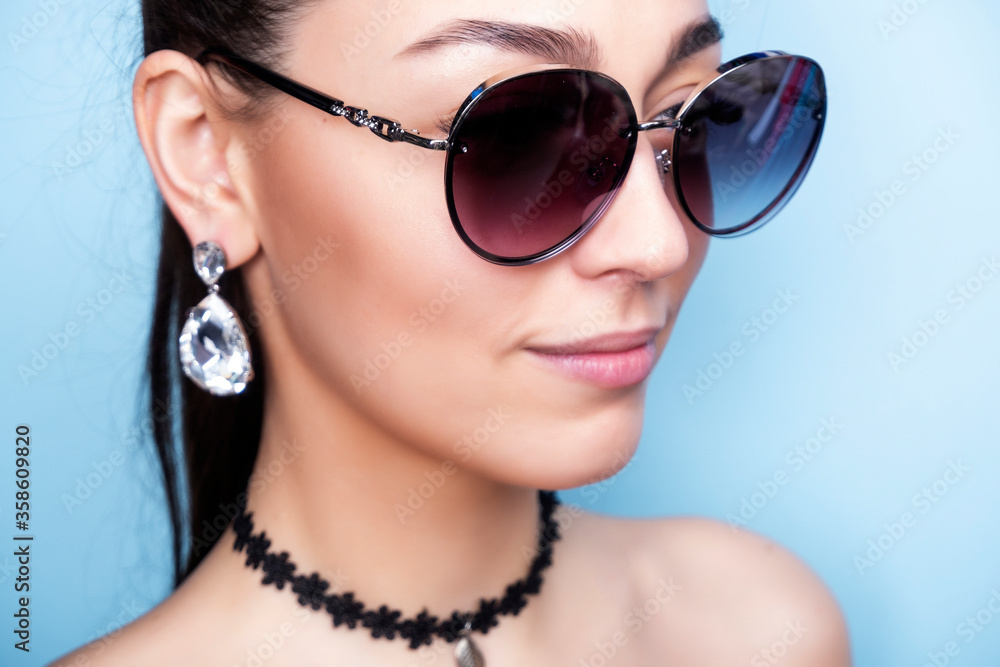 Decoration on the neck. Girl with a black choker. Woman in red sunglasses. Earrings with crystals on the ears. Decoration on the neck. Girl with a black choker. Woman in red sunglasses. Earrings with crystals on the ears.