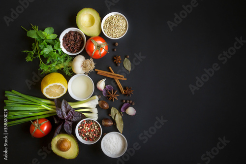 Dry seasonings, spices, herbs and vegetables on a dark background top view.