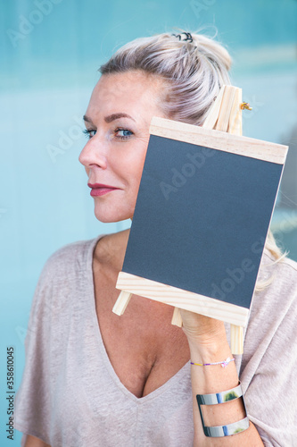 blond woman holding a chalboard photo