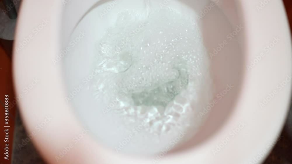 Toilet Flushed Top Down View. Close-up view of a Water flushing down into the toilet bowl in bathroom Toilet Flushed Top Down View. Close-up view of a Water flushing down into the toilet bowl in bathroom