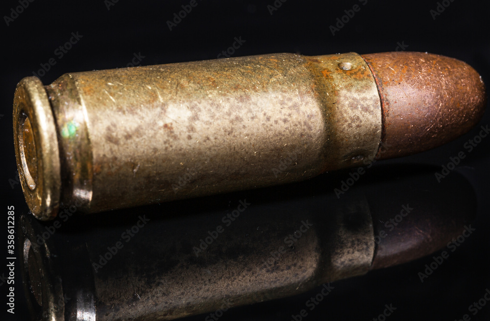 Obraz premium Pocisk pistoletowy. Metalowa luska. Naboj na czarnym tle. Wyizolowane z tla. Zdjecie makro pocisku.