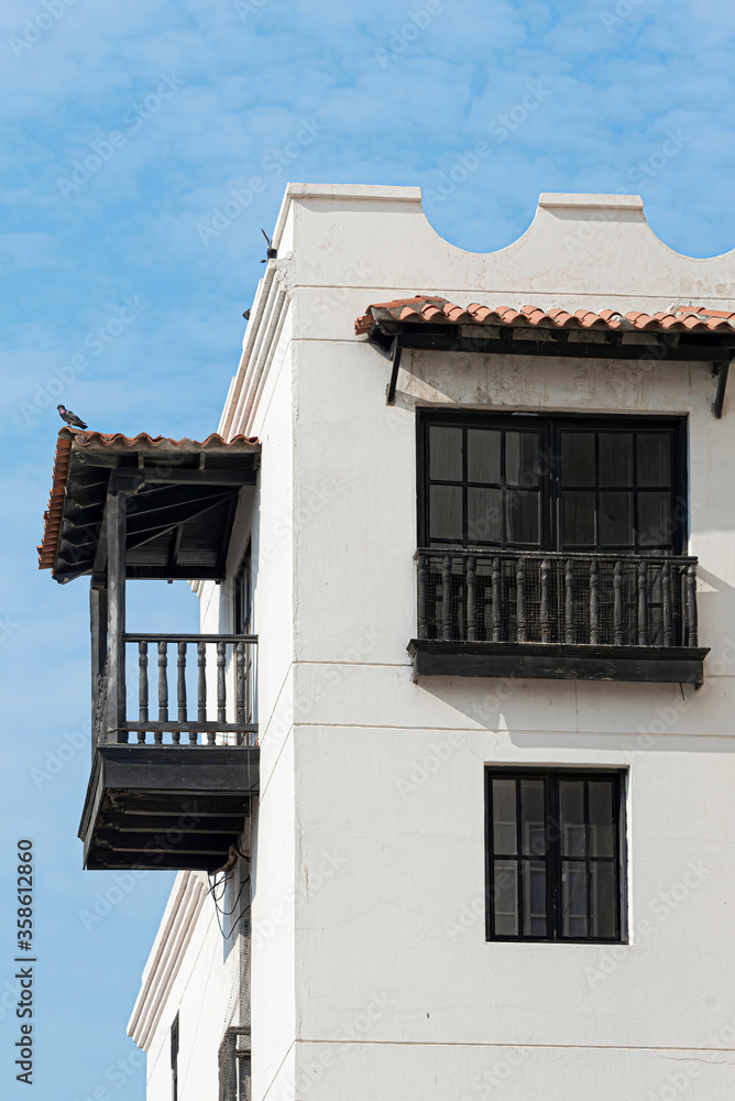 Colonial style house with dark wooden balcony