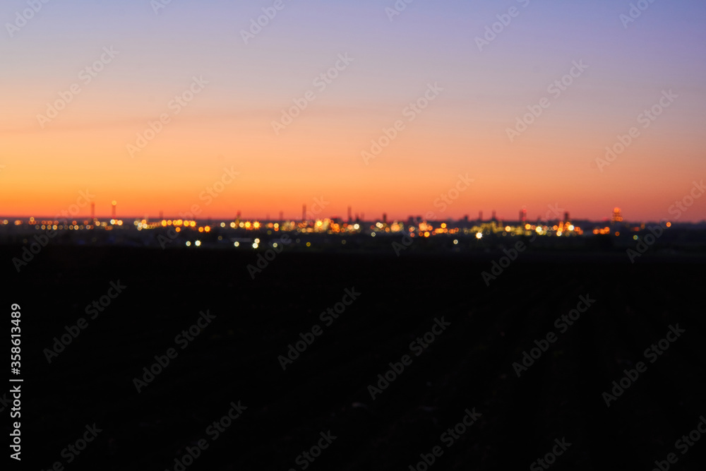 blurred background - evening city on dark earth against the background of the dawn