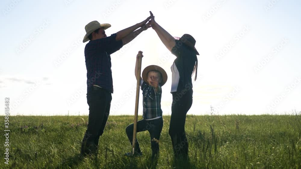 happy family father son and mom teamwork silhouette shows a house and comfort symbol at sunset. happy family parents mother and father and kid children portray house roof hold their hands lifestyle happy family father son and mom teamwork silhouette shows a house and comfort symbol at sunset. happy family parents mother and father and kid children portray house roof hold their hands lifestyle