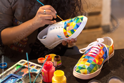 A female designer painting a shoe. photo