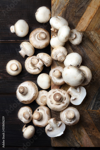 Raw white champignons on a wooden board