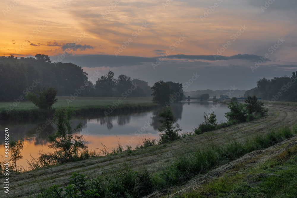 Fog and river Dyje with orange sunrise near Bulhary village before sunrise