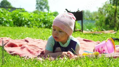a little girl with blond hair is lying in a clearing