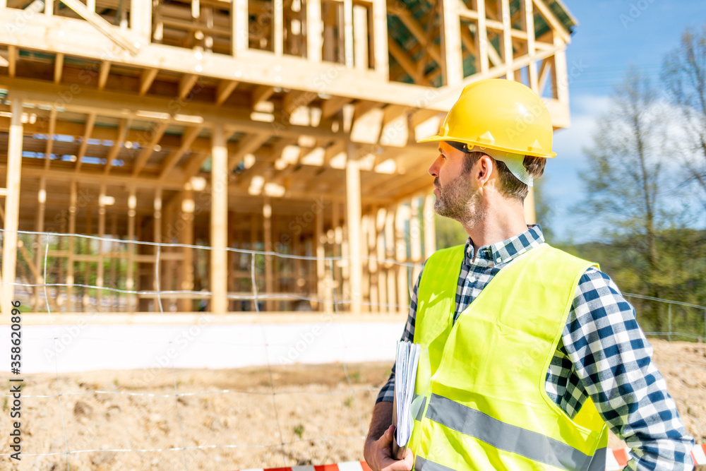 Construction engineer or architect control a construction site of wood frame house Construction engineer or architect control a construction site of wood frame house
